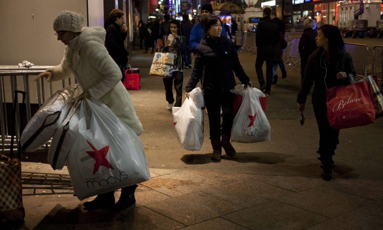 Antes do sol raiar em Nova York, consumidores já deixavam as lojas com as sacolas cheias de compras por quem aproveitou o dia de promoções na 'Black Friday'