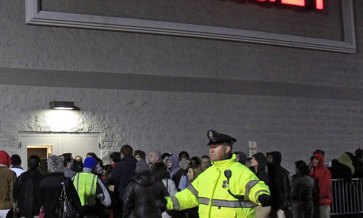 Policial organiza a fila de clientes à espera da abertura de uma loja da Target em Framingham, Massachussetts, na 'Black Friday' do varejo americano