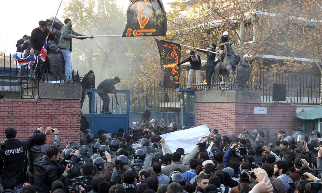 Manifestantes iranianos e policiais em frente à embaixada do Reino Unido em Teerã Foto: ATTA KENARE / AFP