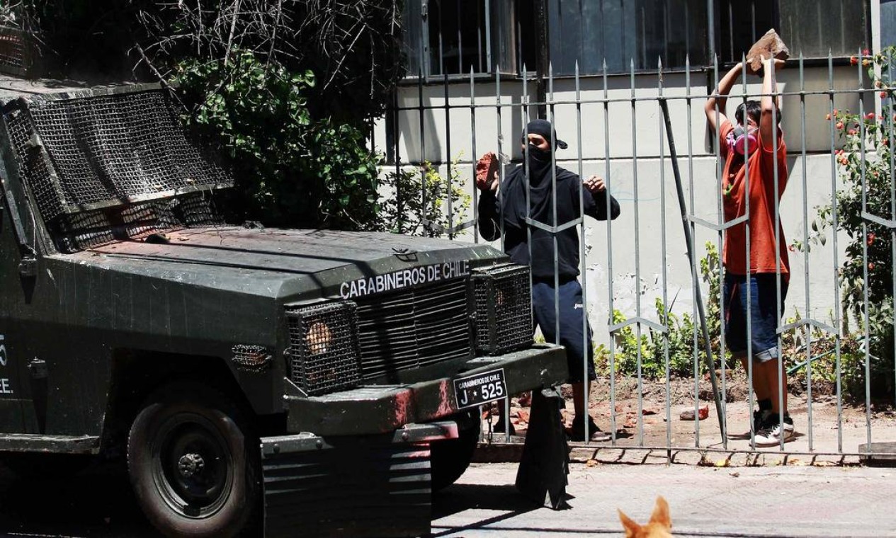 Na capital, encupazados atiram pedras em veículo dos Carabineiros Foto: IVAN ALVARADO / REUTERS