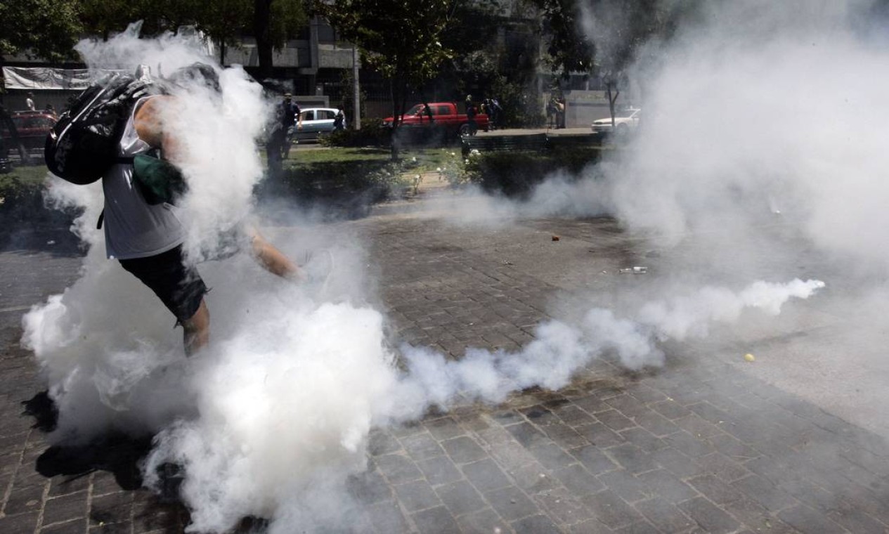 Manifestante chuta bomba gás lançada pela polícia em Santiago Foto: VICTOR RUIZ CABALLERO / REUTERS