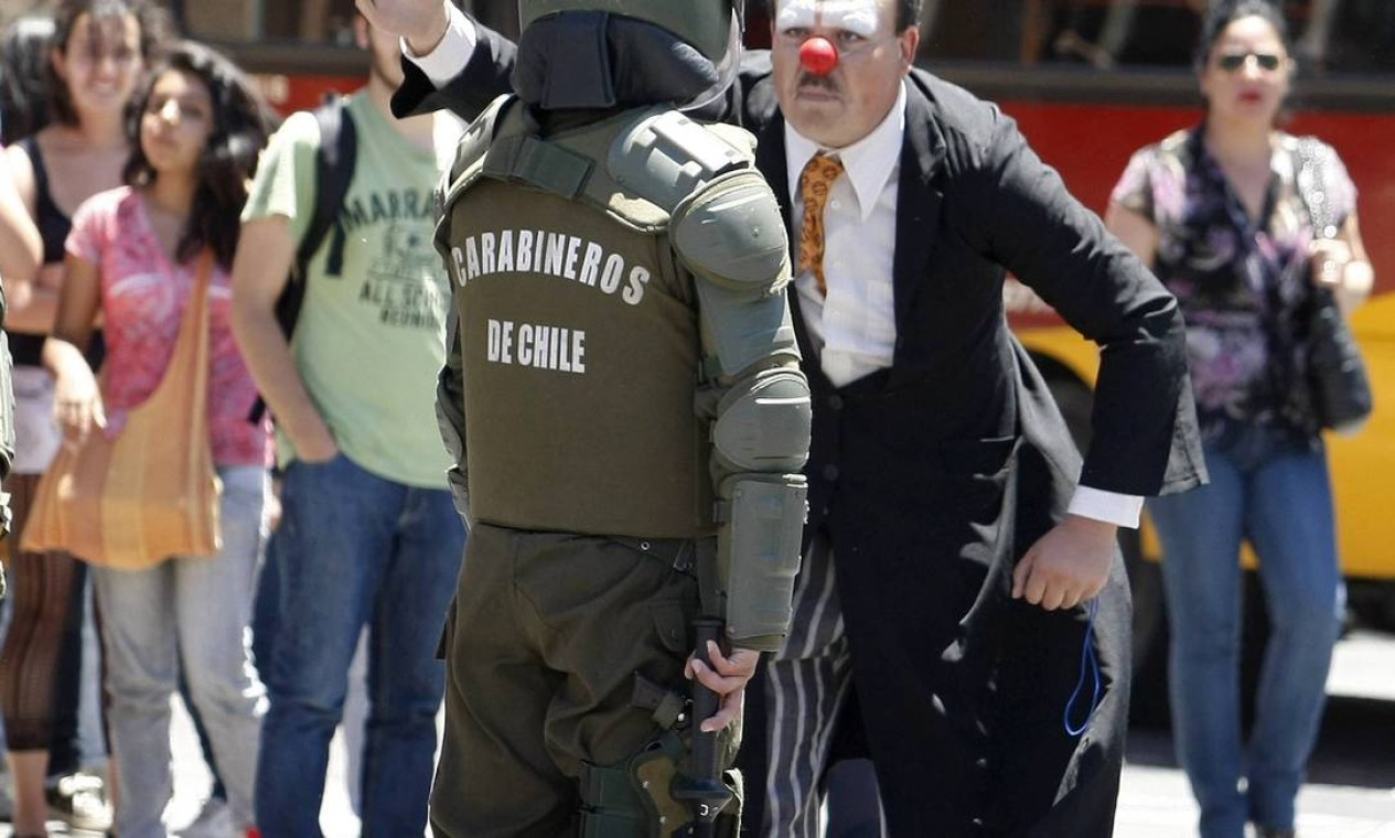 Em Valparaíso, homem vestido de palhaço participa da manifestação e argumenta com policial Foto: Eliseo Fernandez / REUTERS