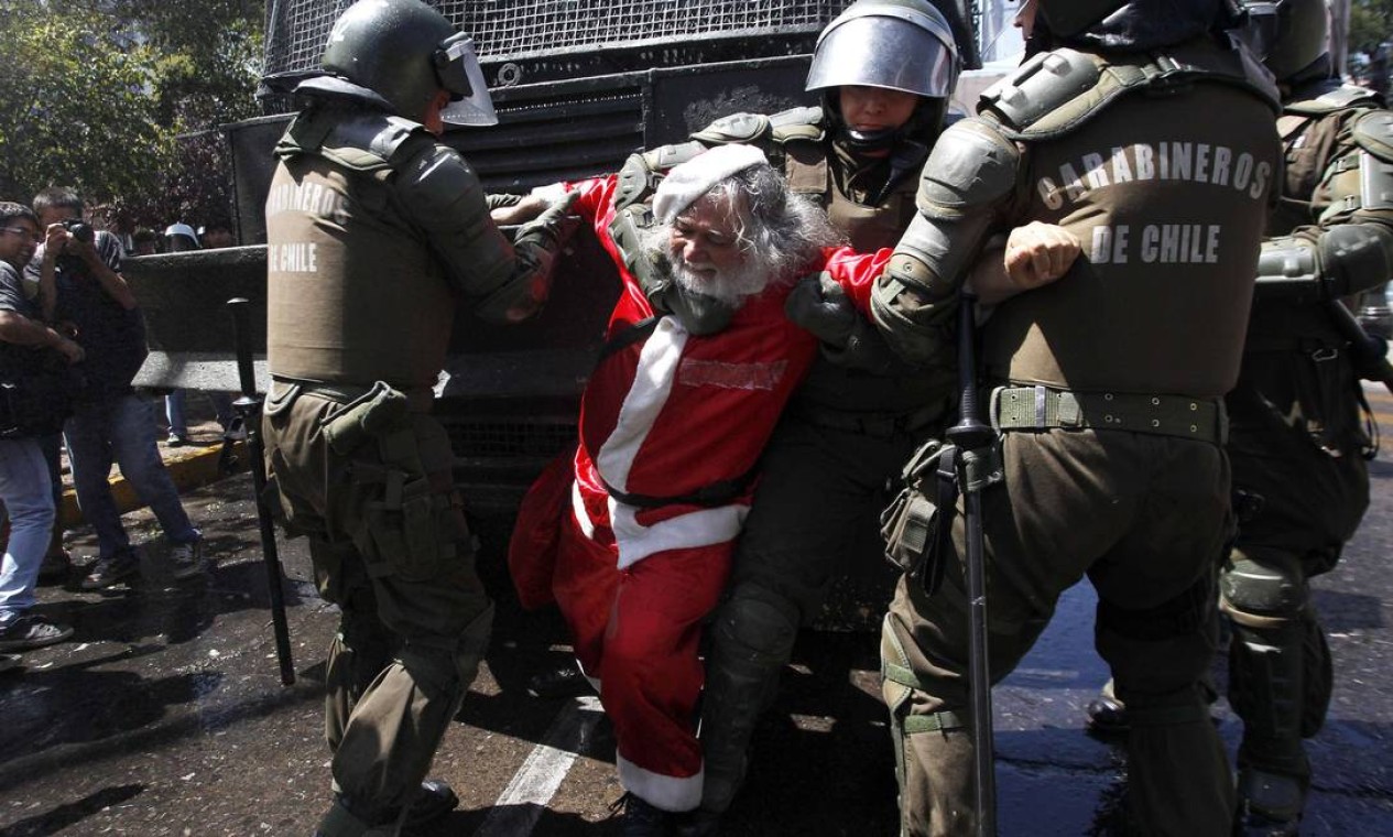 Papai Noel é agarrado pelos policiais Foto: IVAN ALVARADO / REUTERS