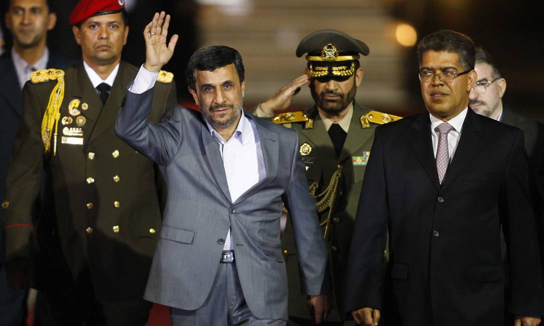 O presidente do Irã Mahmoud Ahmadinejad acena ao chegar à Venezuela, ao lado do vice-presidente Elias Jaua (à direita), no aeroporto at Simon Bolivar, em Caracas Foto: Carlos Garcia Rawlins / REUTERS