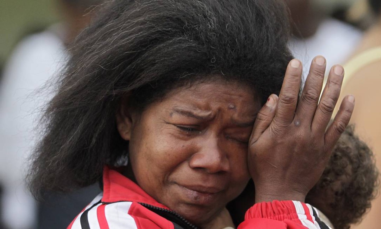 Mulher se emociona ao deixar a comunidade Foto: O Globo / Marcos Alves
