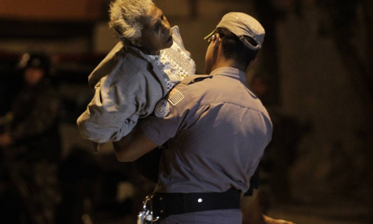 Uma senhora ferida foi socorrida por policiais Foto: O Globo / Marcos Alves