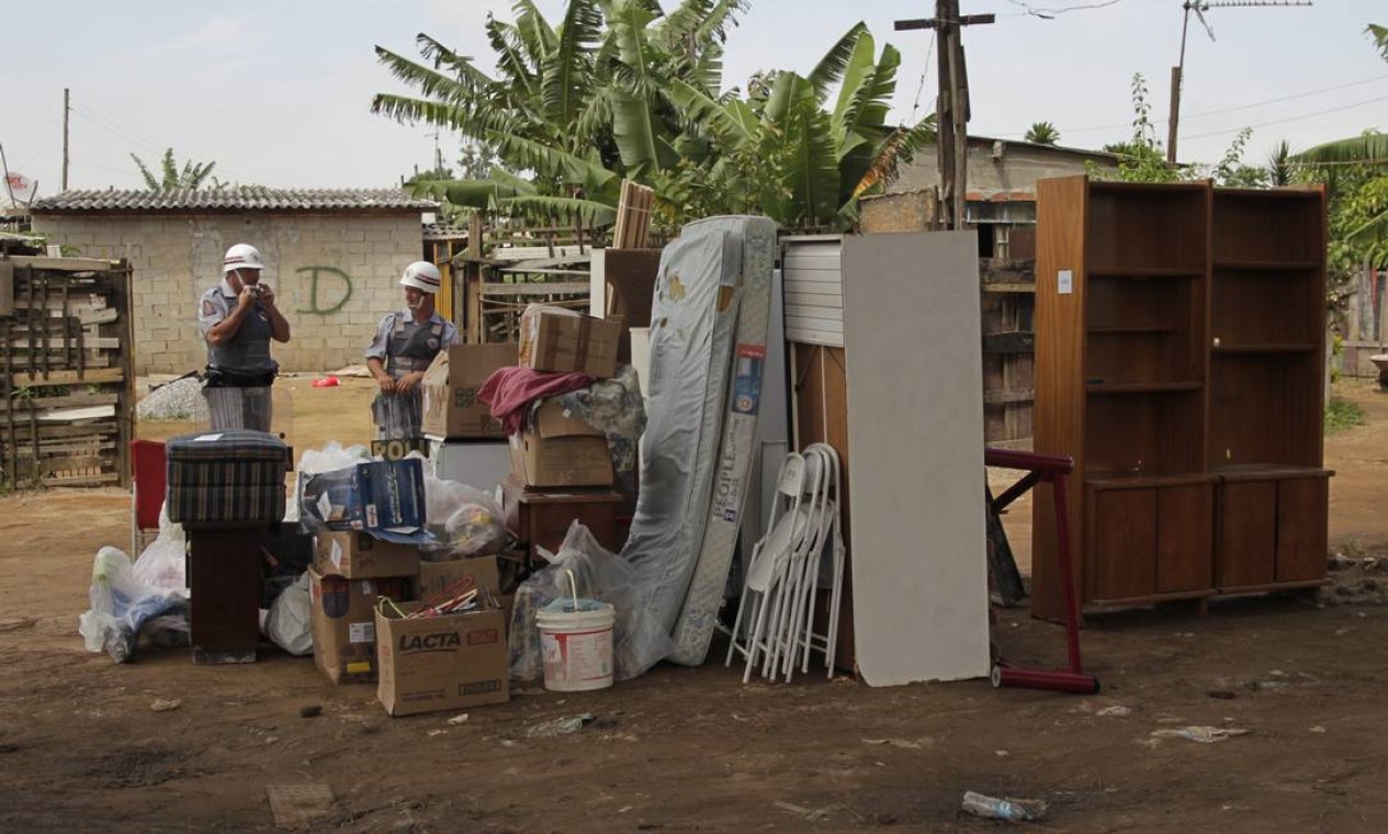 Os moradores que tiveram suas casas identificadas estão retirando seus móveis com ajuda de trabalhadores braçais Foto: Marcos Alves / O Globo