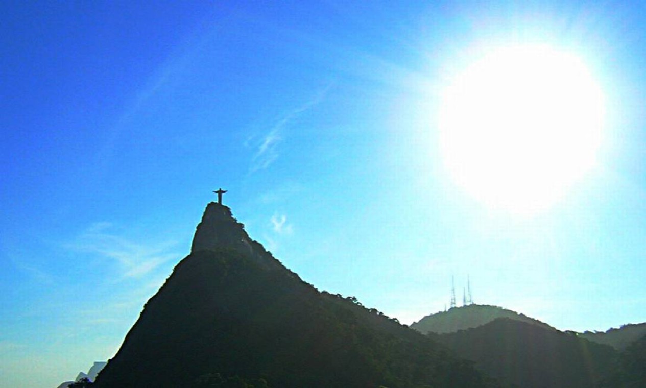 Sol ‘estoura’ por trás do Cristo Redentor, em meio ao céu azul Foto: Eu-repórter / Leitor Gustavo Macbaú