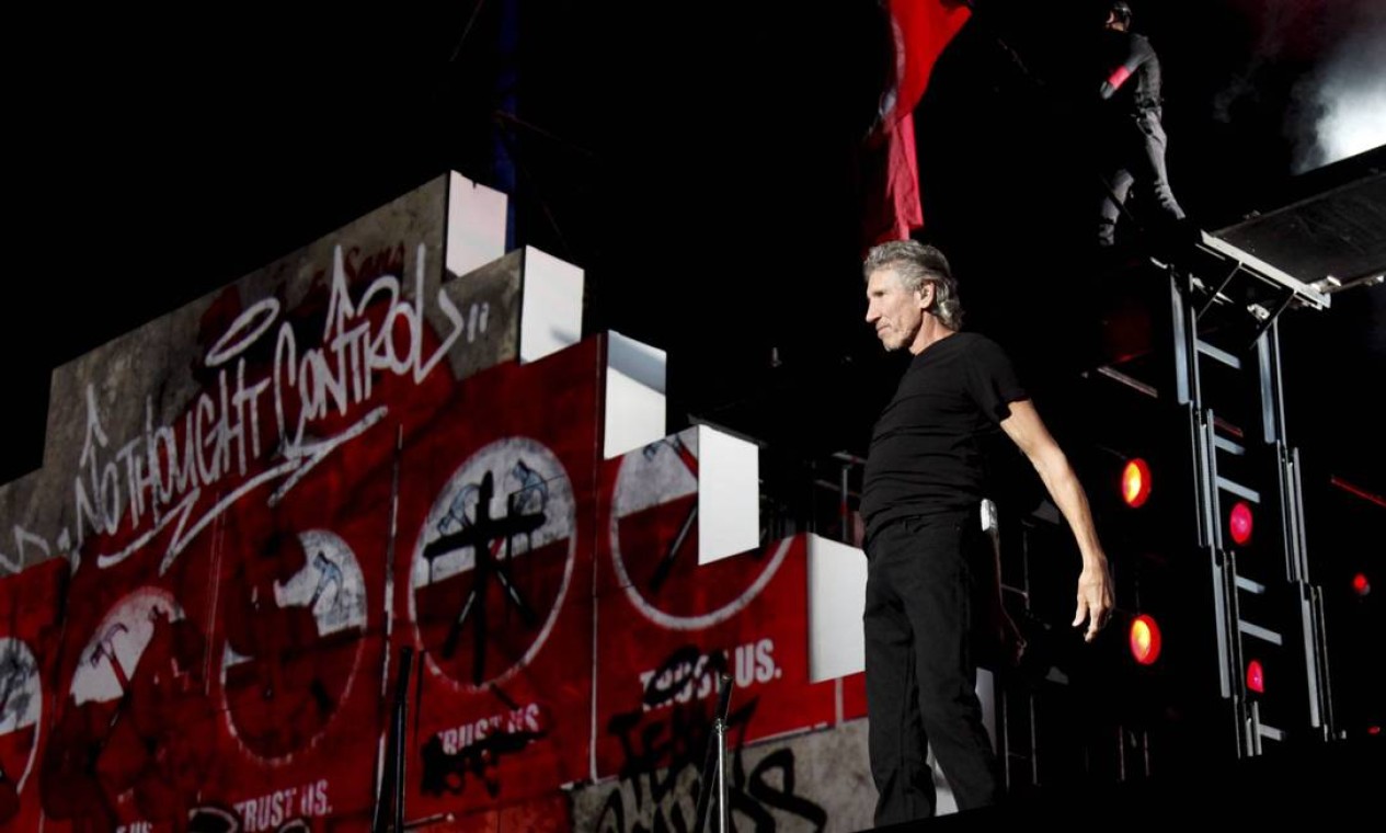 Waters posa ao lado do gigante muro erguido no palco Foto: Mônica Imbuzeiro / Agência O Globo