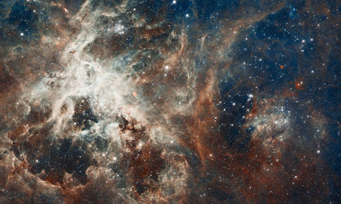 
Imagem do telescópio espacial Hubble mostra o berçário estelar de 30 Doradus, localizado na Nebulosa da Tarântula, a cerca de 170 mil anos-luz da Terra
Foto: Divulgação/Hubble