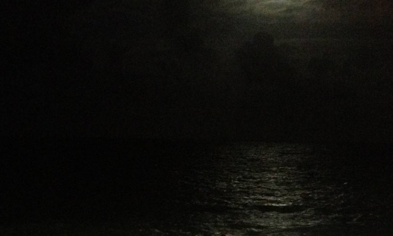 Entre nuvens, a lua aparece em Praia dos Artistas, em Natal Foto: Foto do leitor Silvio Bezerra / Eu-Repórter