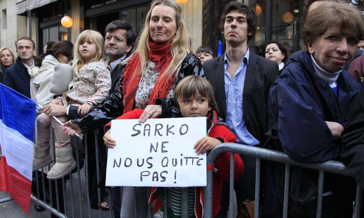 ‘Não nos deixe, Sarkozy’, diz cartaz segurado por apoiadores do presidente francês derrotado nas eleições deste domingo Foto: Jacques Demarthon/AFP - 06/05/2012