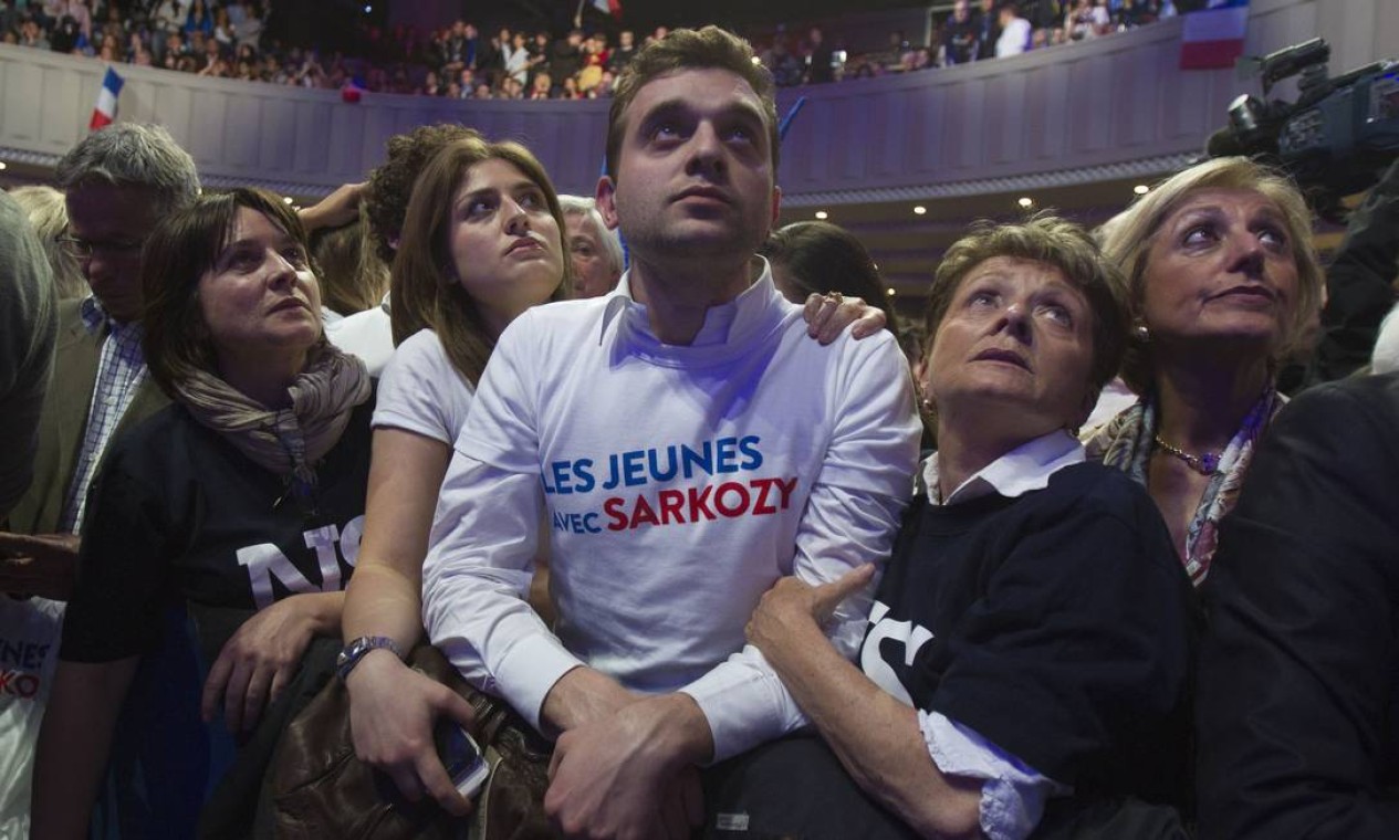 Apoiadores de Nicolas Sarkozy (na camiseta, lê-se ‘Juventude por Sarkozy’) aguardam os resultados preliminares na sede da União por um Movimento Popular (UMP), o partido do presidente derrotado Foto: Michel Euler/AP - 06/05/2012