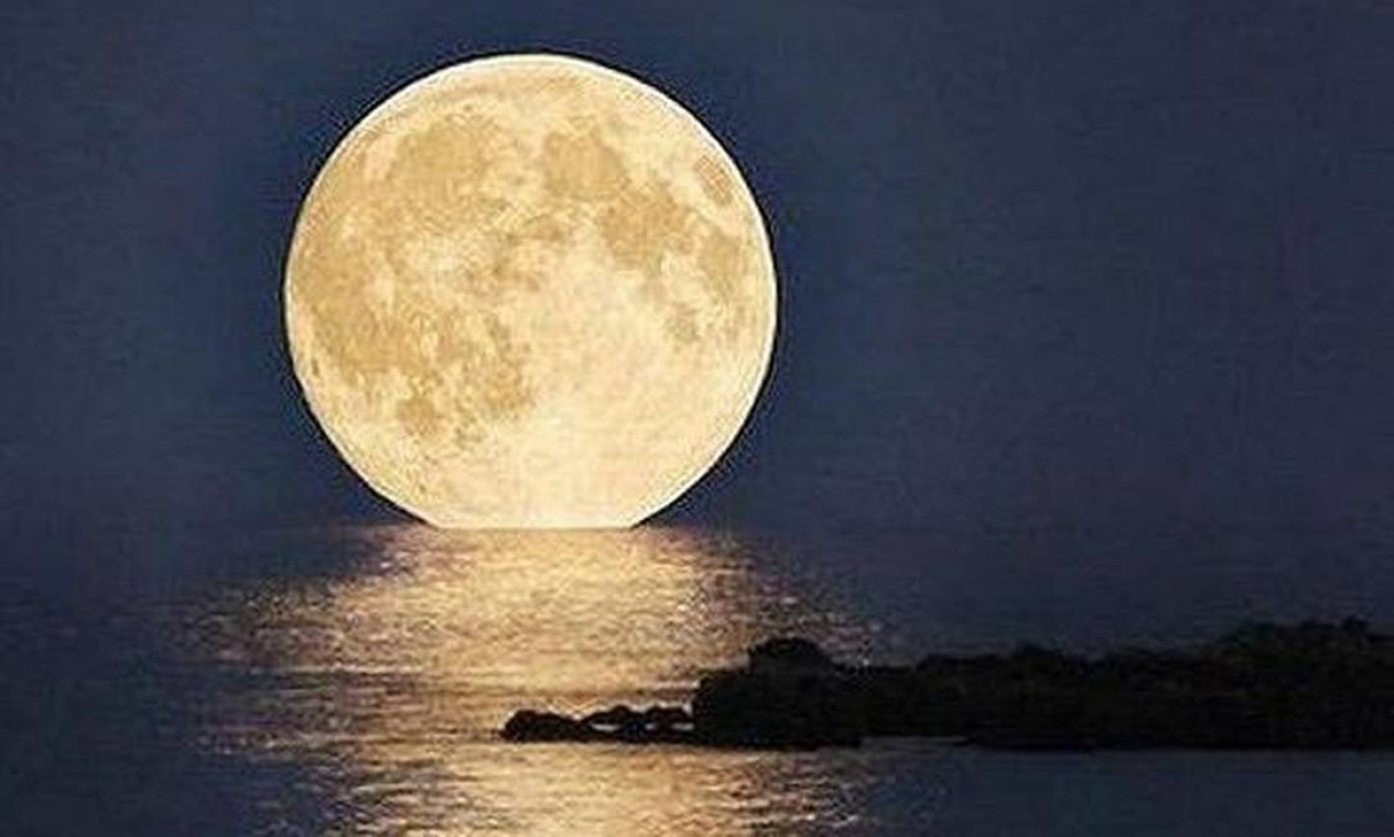A lua parece flutuar sobre o mar. À 00h35 de domingo, a lua atingiu sua fase mais cheia ao mesmo tempo em que esteve no perigeu (ponto em que fica mais perto da Terra), estando maior e mais brilhante Foto: Foto da leitora Glaucia Menezes, via Facebook / Eu-Repórter