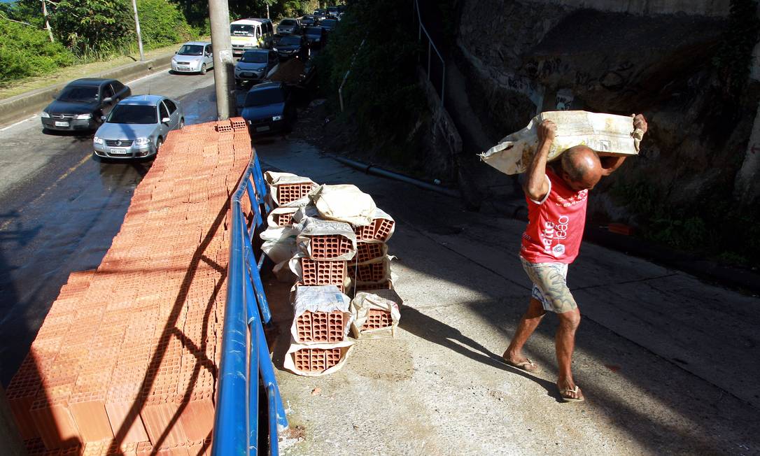 
Homem carrega tijolos para o interior do Vidigal
Foto: Gabriel de Paiva / O Globo
