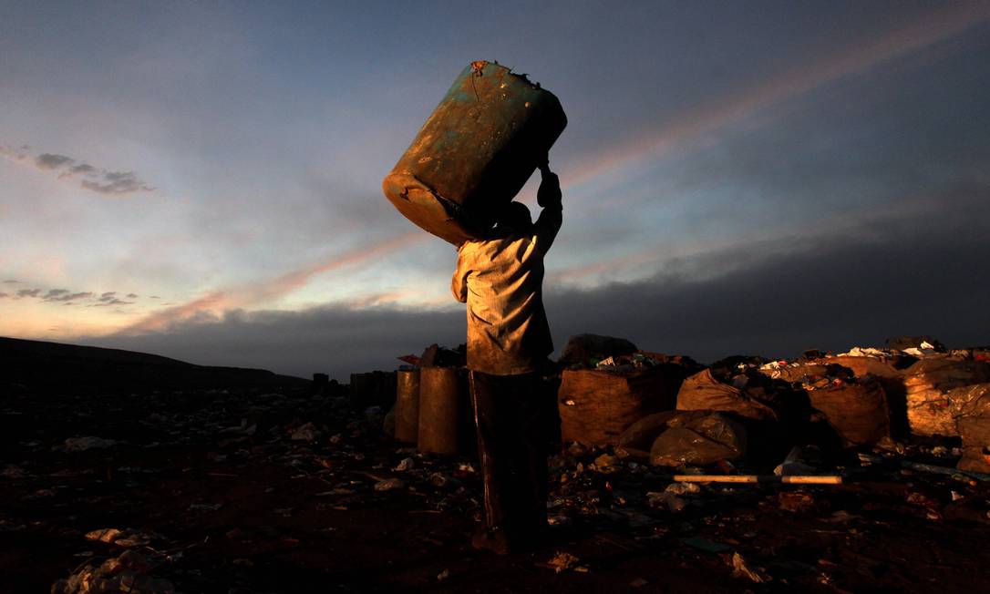 
A man carries a large canister as the sun rises over the landfill that operates 24 hours a day and provides an income to 1,700 people
Foto:
Domingos Peixoto
/
O Globo
