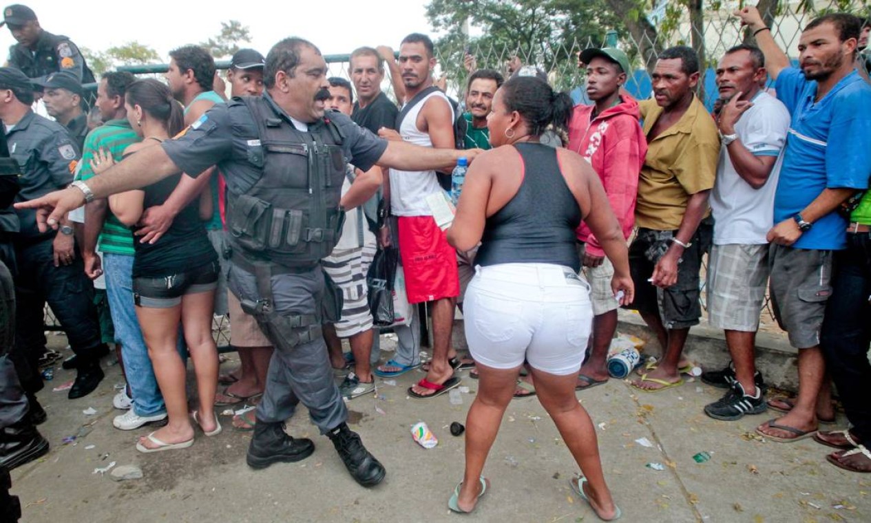 Mulher tenta argumentar com PM. Fechamento do Aterro de Gramacho está marcado para domingo Foto: Pedro Kirilos / O Globo