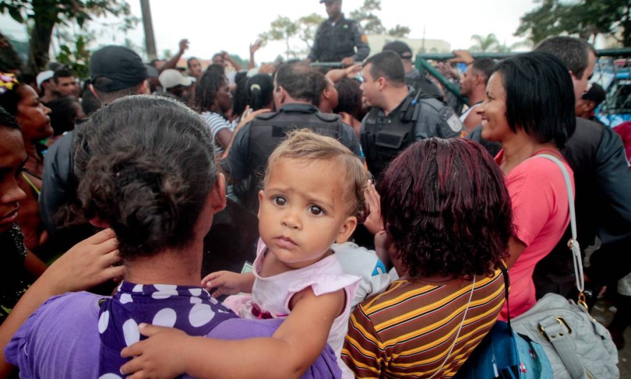 Mulher com criança aguarda na fila para receber o benefício Foto: Pedro Kirilos / O Globo