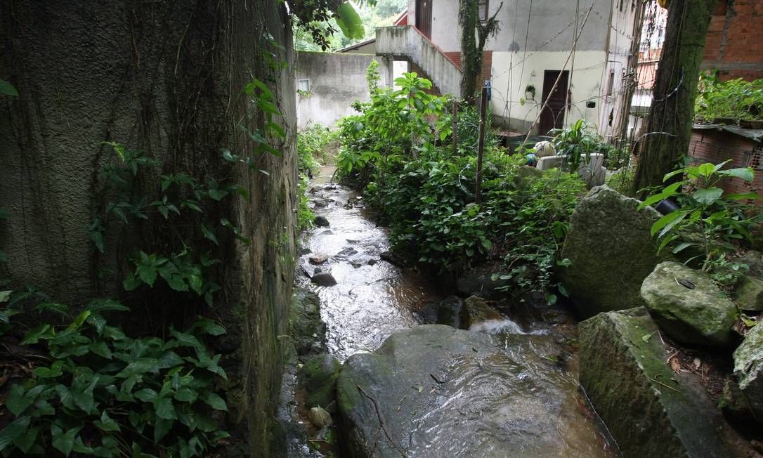 O MEIO: o curso d’água estreitado pela favela dos Guararapes, no Cosme Velho, começa a receber esgoto Foto: Custodio Coimbra
