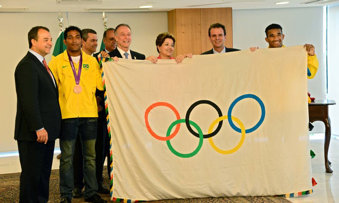 
Gafe olímpica. Na apresentação da bandeira a Dilma, autoridades e atletas tocam o símbolo sem luvas
Foto: João Paulo Engelbrecht / Divulgação