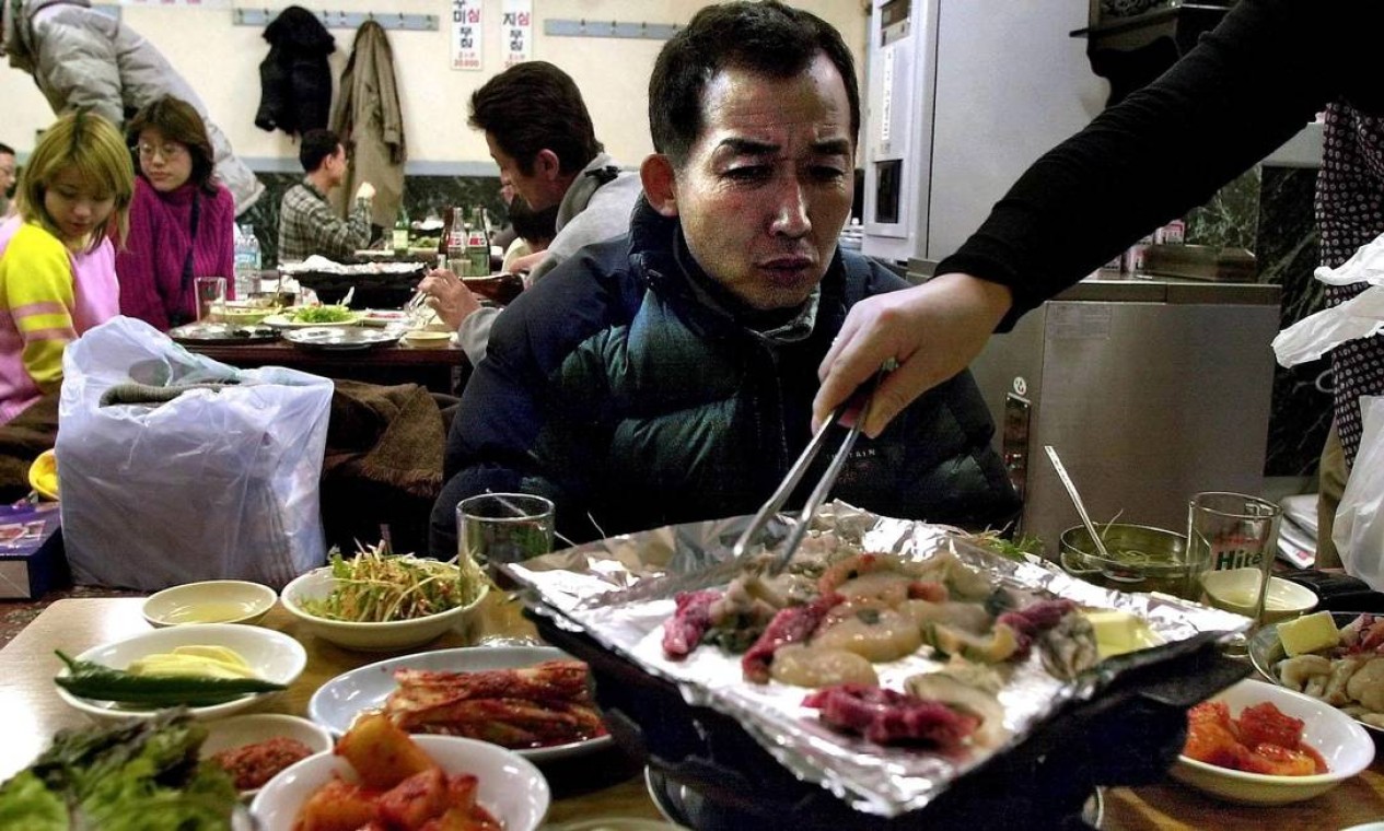 Quando bater a fome, uma boa opção é o tradicional “korean barbecue”, que reúne carne, frutos do mar e legumes. Foto: CHOO YOUN-KONG / AFP