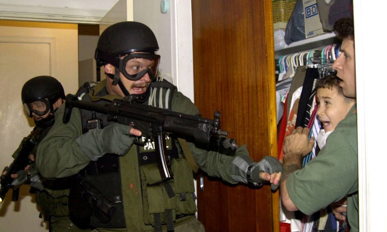 A foto correu o mundo. Em 22 de abril de 2000, agentes armados entraram na casa em que parentes abrigavam Elián Gonzalez em Miami para buscar o menino. Sua mãe havia morrido num naufrágio quando tentava chegar à Flórida e o menino foi recolhido pelo pescador Donato Dalrymple (na foto). Apesar da resistência de parentes nos EUA, o menino foi devolvido ao pai, em Cuba Foto: AP