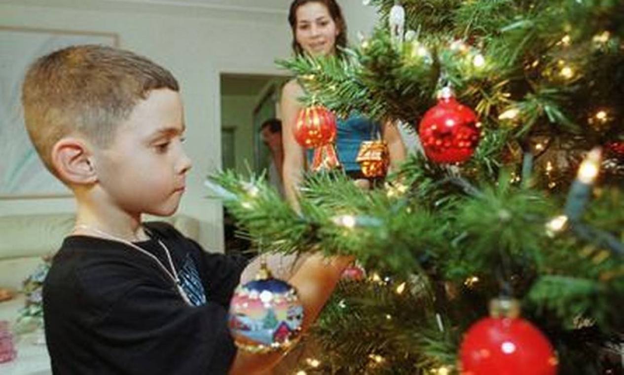 Elián decora uma árvore de Natal com a prima Marisleysis González, em Miami. Uma batalha corria nos tribunais sobre o destino do menino Foto: Reuters/22-12-1999