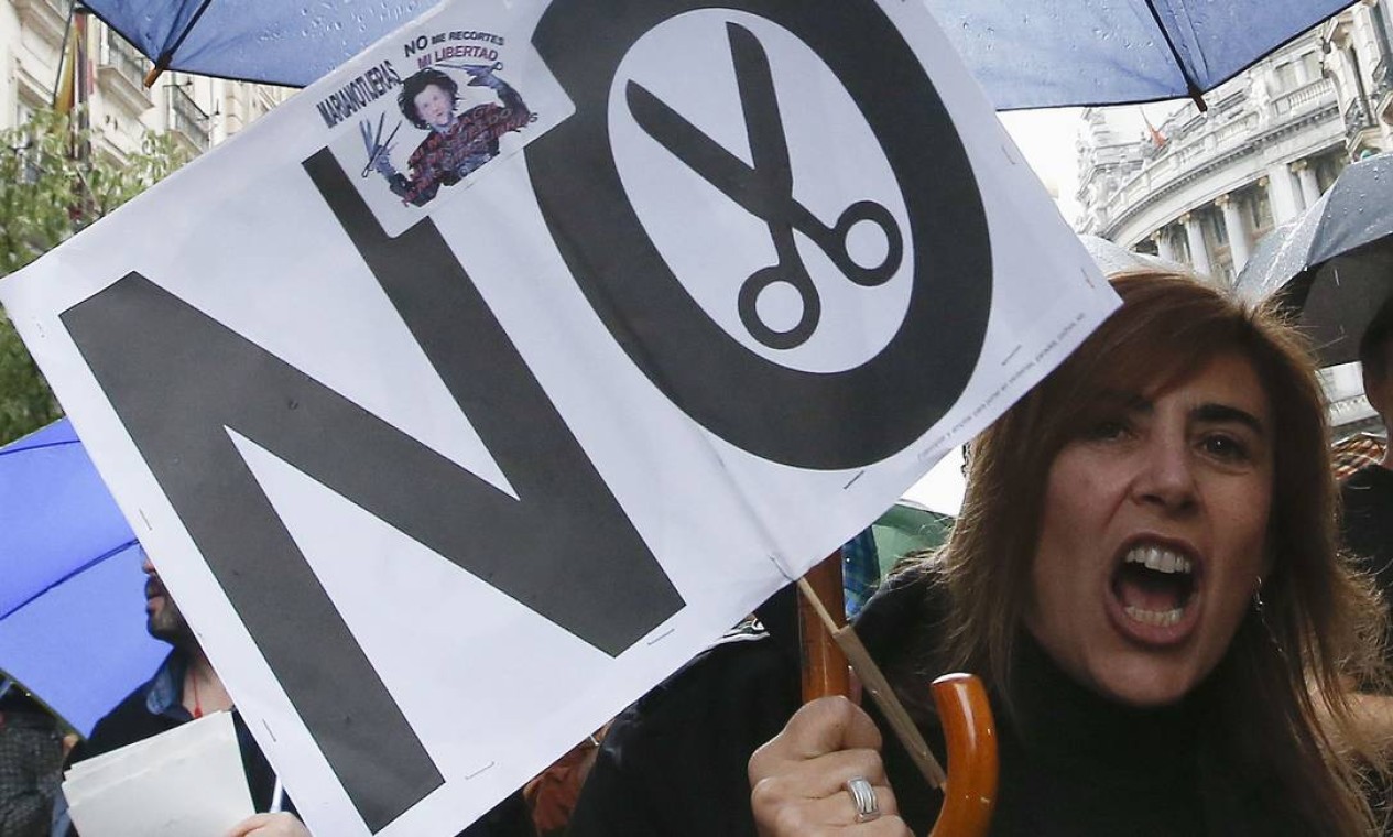 Uma mulher carrega um banner que diz “não” em referência aos cortes do governo espanhol durante manifestação em Madri Foto: ANDREA COMAS / REUTERS
