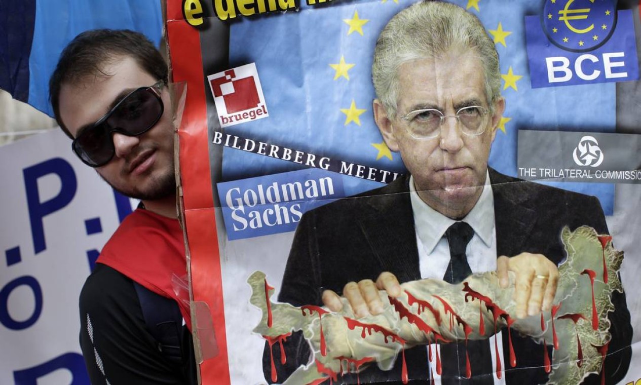 Um manifestante segura um cartaz com a cara do primeiro-ministro italiano, Mario Monti Foto: TONY GENTILE / REUTERS