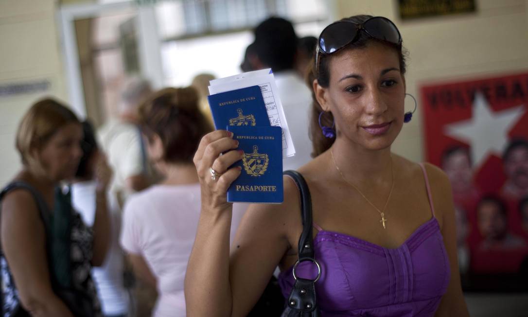 
Mulher mostra seu passaporte num escritório de migração em Havana, Cuba: medidas flexibilizam saída e entrada de cubanos no país
Foto: AP/16-10-2012