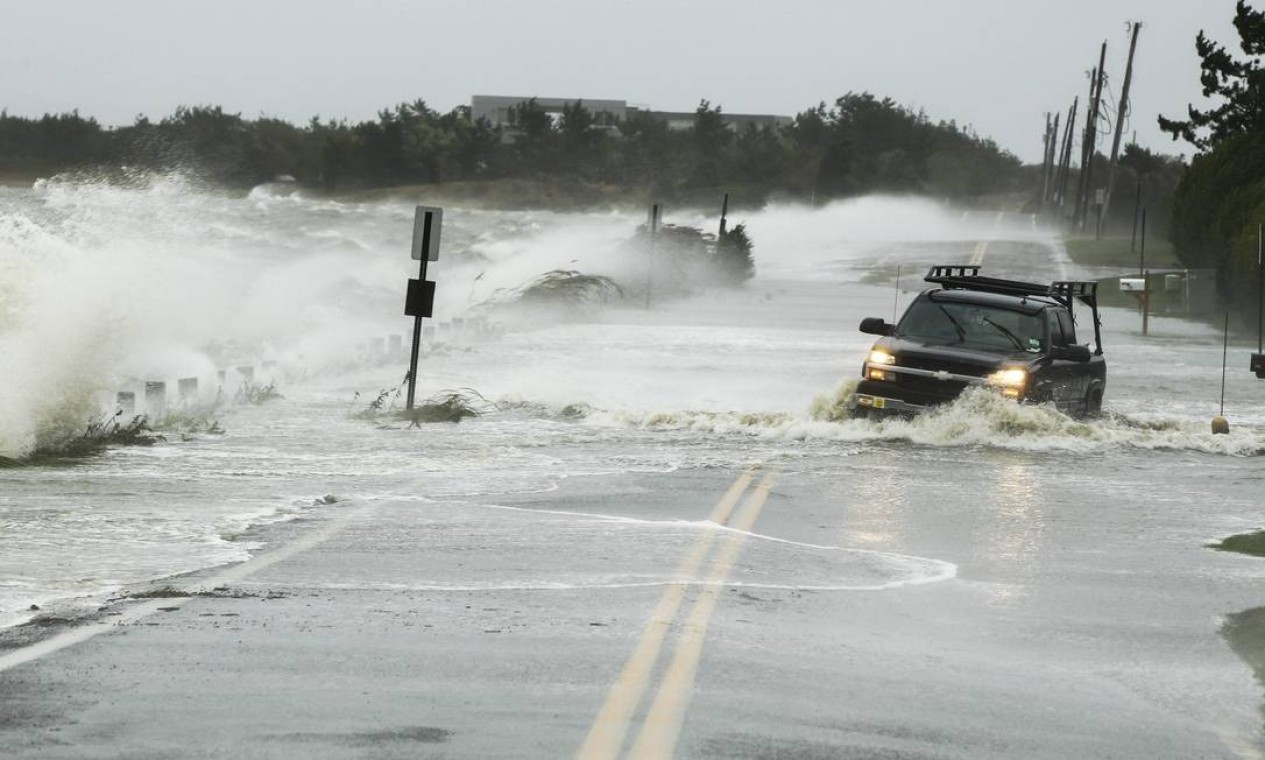 Um carro é arrastado pelas ondas de praia em Southampton, no estado de Nova York Foto: REUTERS