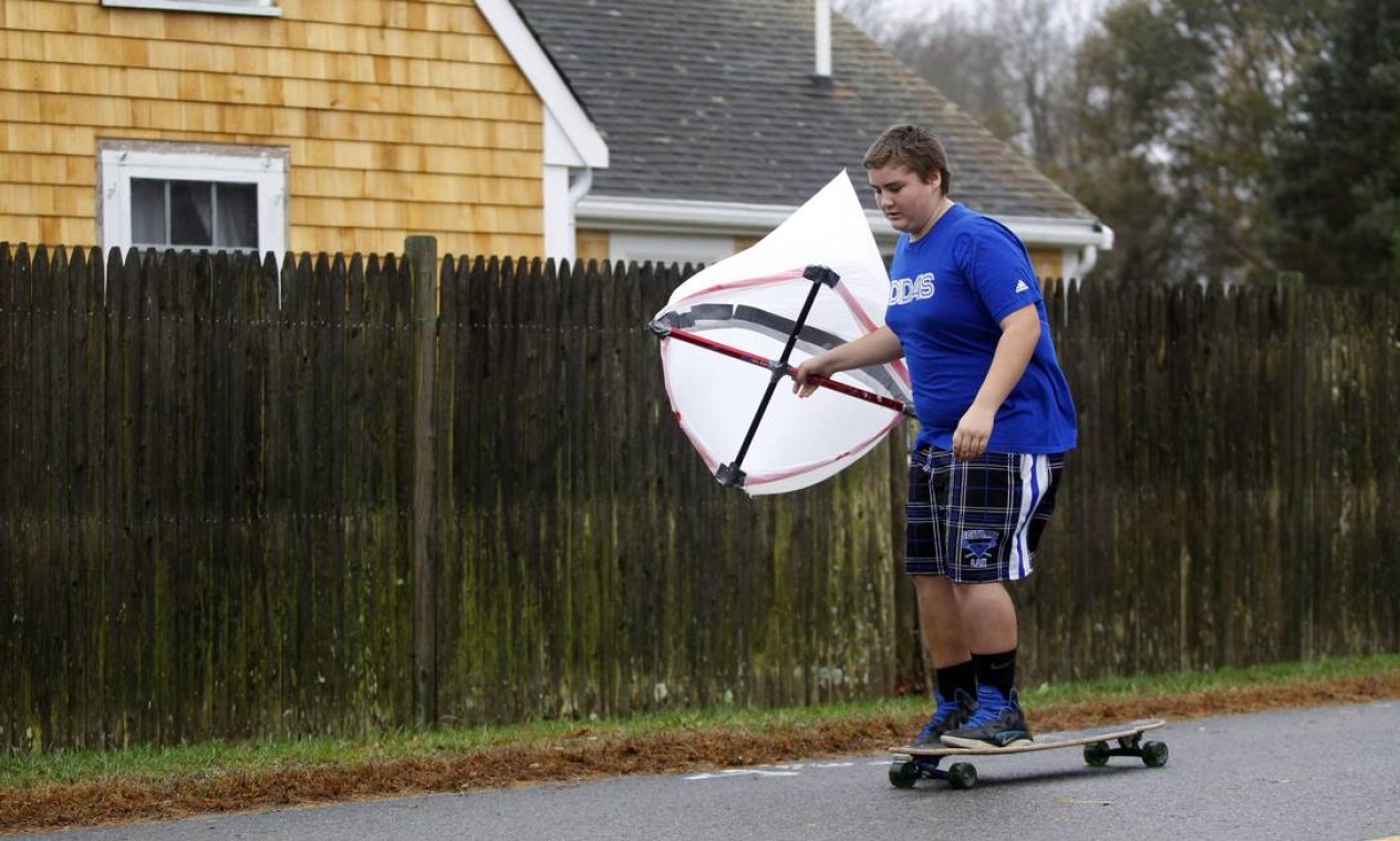 Garoto usa uma pipa e o vento para impulsionar o skate em Scituate, Massachusetts Foto: Reuters