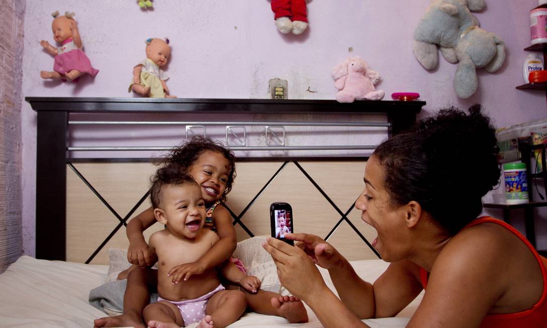
Sem certidão de nascimento, Camila fotografa as duas filhas, Camille, de 2 anos, e Sofia, de 5 meses, também sem registro oficial, em casa minúscula no Gamboa
Foto: Márcia Foletto / O Globo