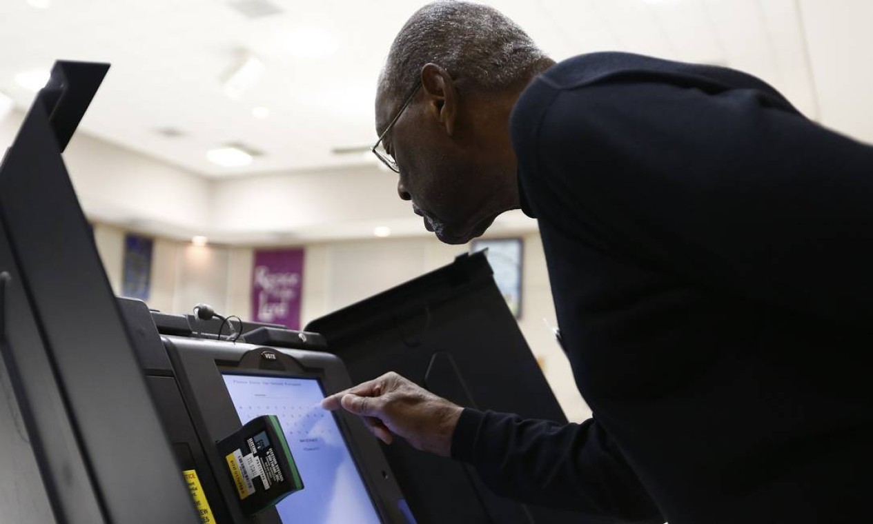 Bill Partlow, chefe de uma seção eleitoral em Pineville, Carolina do Norte, desbloqueia máquina para início da votação Foto: Reuters