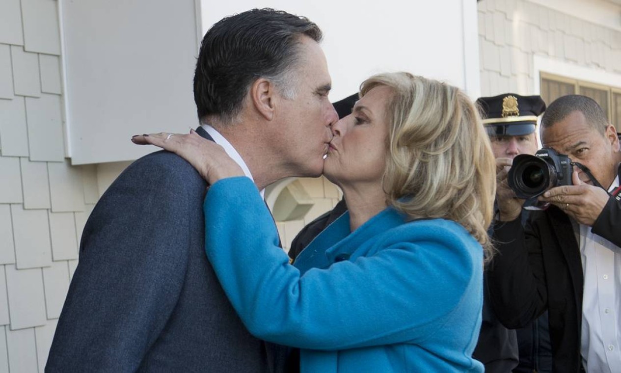 Romney beija a mulher na saída da seção eleitoral Foto: AFP