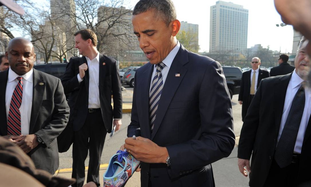 Obama autografa tênis de partidário em Chicago. Sem precisar votar hoje, o presidente aproveita o dia para fazer campanha e relaxar Foto: AFP
