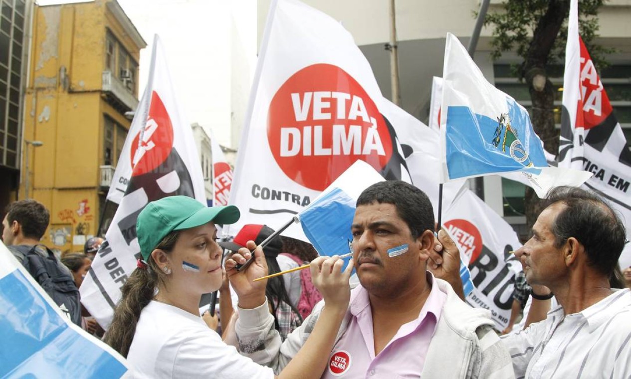 Manifestantes com a cara pintada com as cores da bandeira oficial do estado do Rio de Janeiro (azul e branco) em defesa dos royalties do petróleo Foto: Marcelo Carnaval / Agência O Globo
