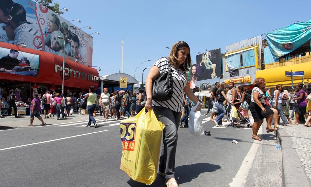 Mulher atravessa uma das ruas de comércio do bairro, que tem cerca de 329 mil habitantes Foto: Carlos Ivan / Agência O Globo