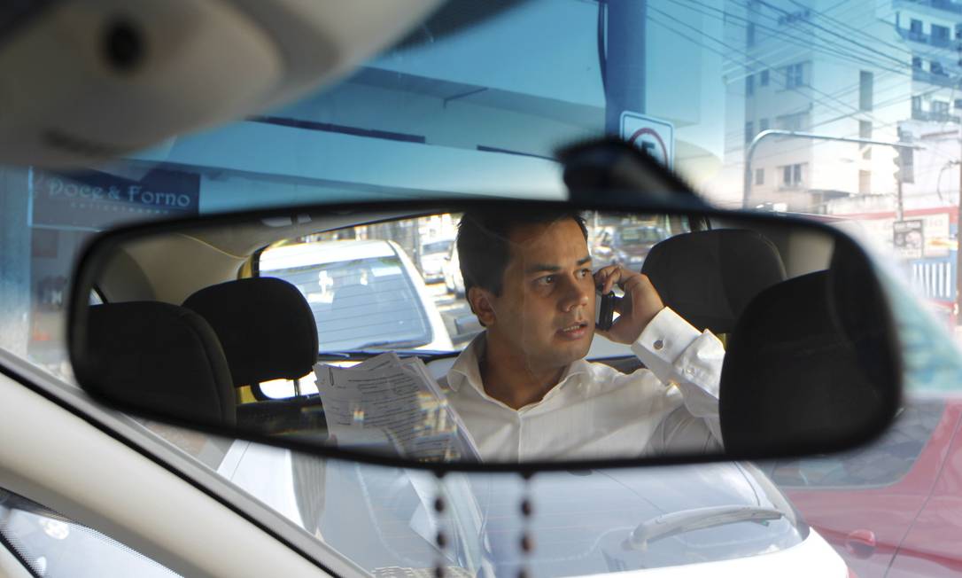 
O neurologista Oscar Bacelar fala ao celular no táxi, entre a sua casa e o consultório: ‘quando chego, posso me dedicar mais às demandas do dia’, afirma ele
Foto: Custódio Coimbra / O Globo