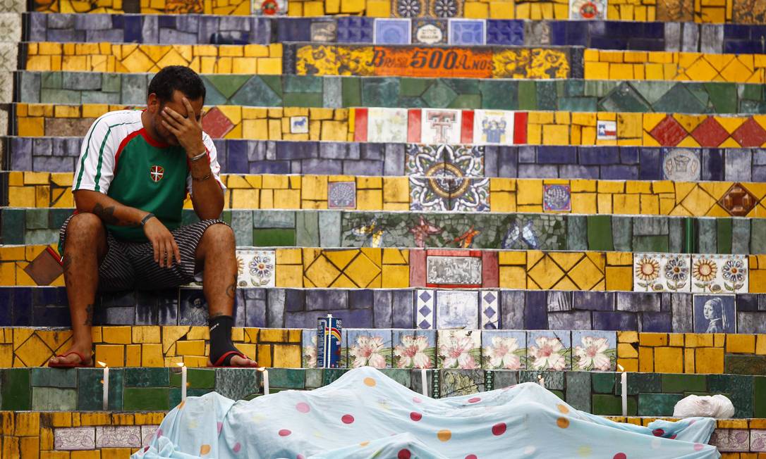 Amigo de Selarón, o argentino Cesar Gomez, chora ao lado do corpo do artista nas escadarias da Lapa Foto: Pablo Jacob / O Globo