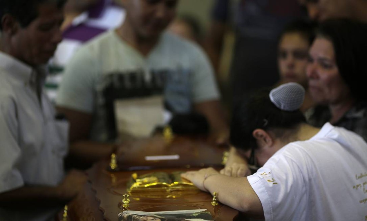 Familiares acompanham enterro de vítima Foto: RICARDO MORAES / REUTERS