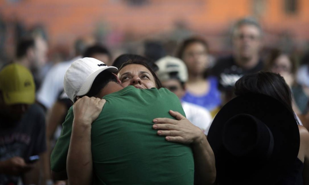 Familiares se consolam em enterro de vítimas Foto: RICARDO MORAES / REUTERS