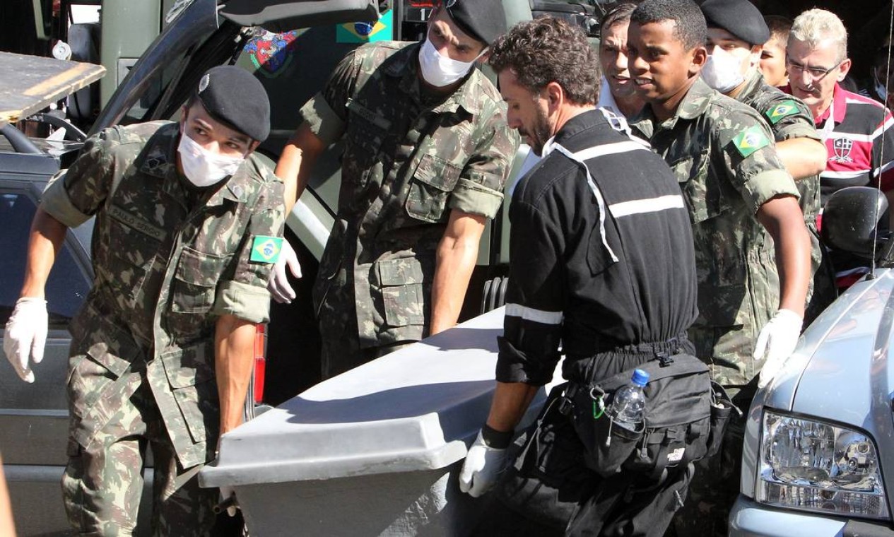 Soldados do exército carregam caixão com o corpo de uma das vítimas de incêndio Foto: Nabor Goulart / AP