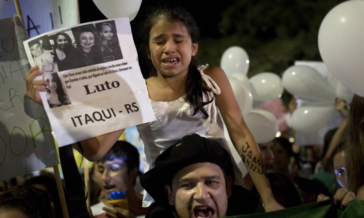 Com cartaz na mão, criança chora Foto: Felipe Dana / AP
