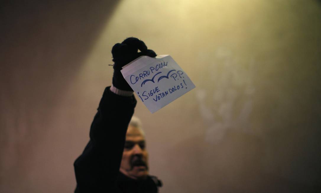 
Manifestante em Málaga mostra um envelope onde se lê “Corrupção P.P. Continue votando neles”
Foto: Jon Nazca / Reuters