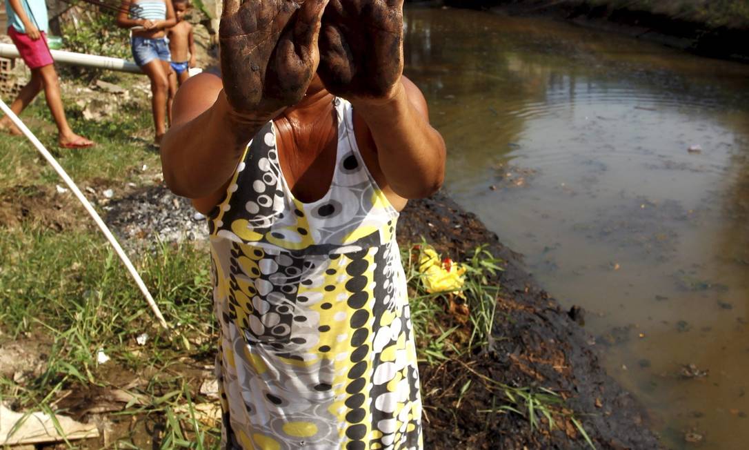 
Nas mãos. Moradora de Duque de Caxias mostra a contaminação do Rio Pilar
Foto: Custódio Coimbra / O Globo