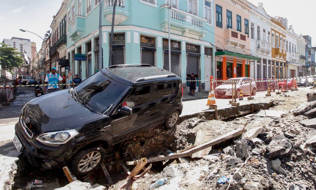 Rastro de destruição na quarta-feira: carro cai em buraco de obra na Rua dos Inválidos, no Centro Foto: Pedro Kirilos / Agência O Globo