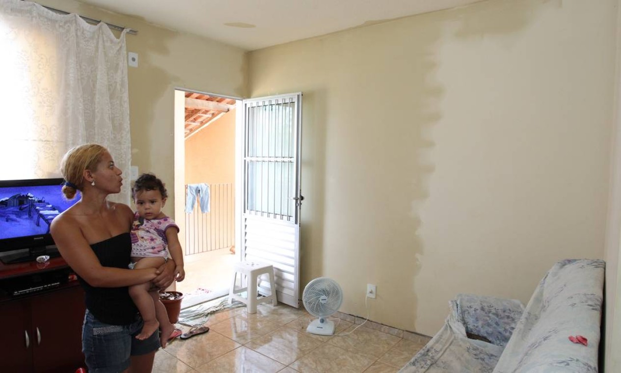 No Condomínio Almada, em Santa Cruz, Daniele de Castro mostra as paredes de sua casa molhadas devido à infiltração. Foto: Carlos Ivan / O Globo