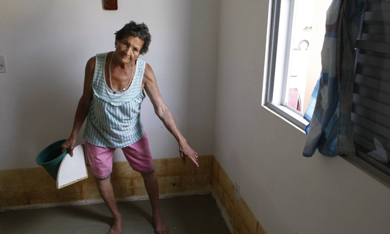 Tereza Ferreira mostra a marca da água suja que invadiu sua casa. Foto: Eduardo Naddar / O Globo