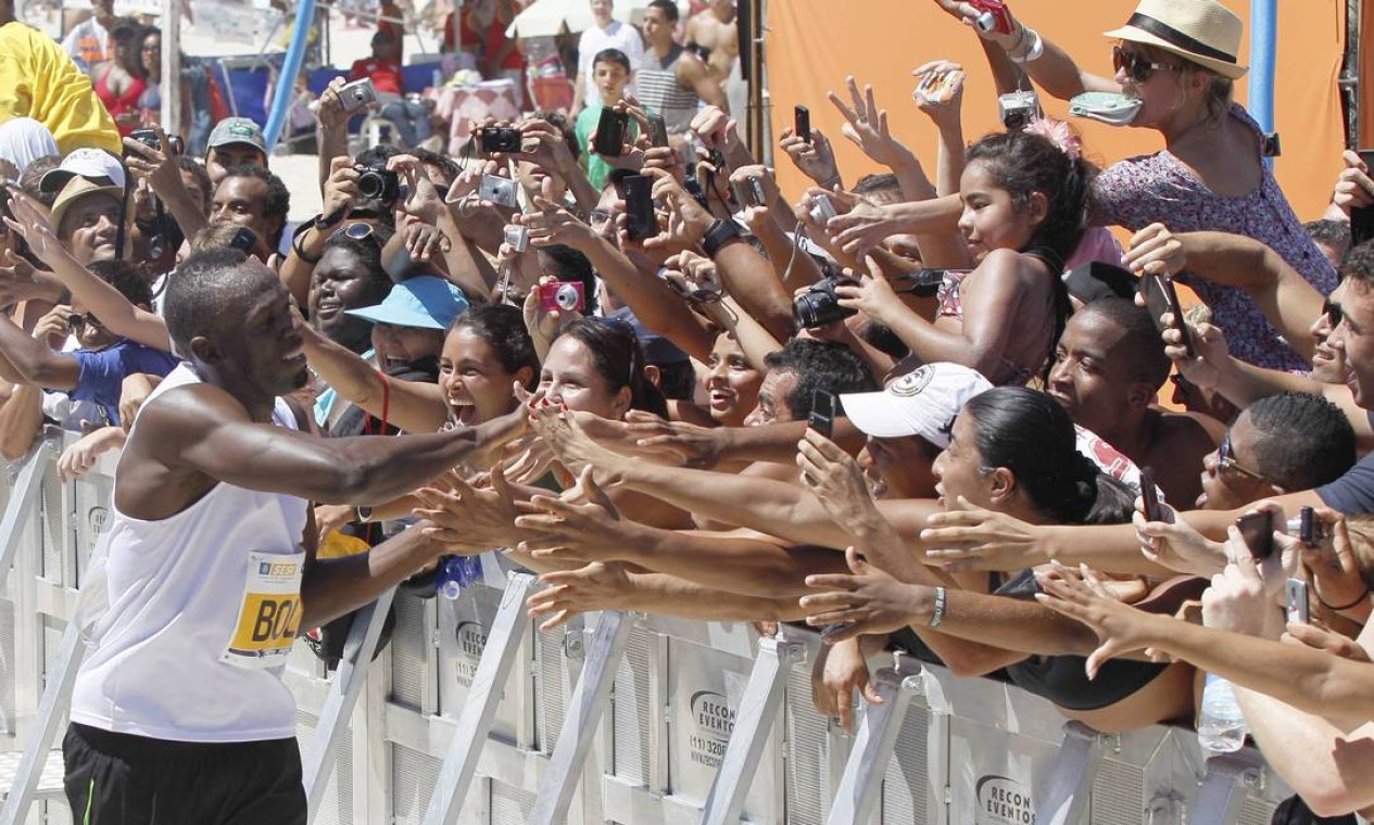 Na hora da premiação, Bolt foi cumprimentar a galera na praia Foto: Cezar Loureiro / Agência O Globo